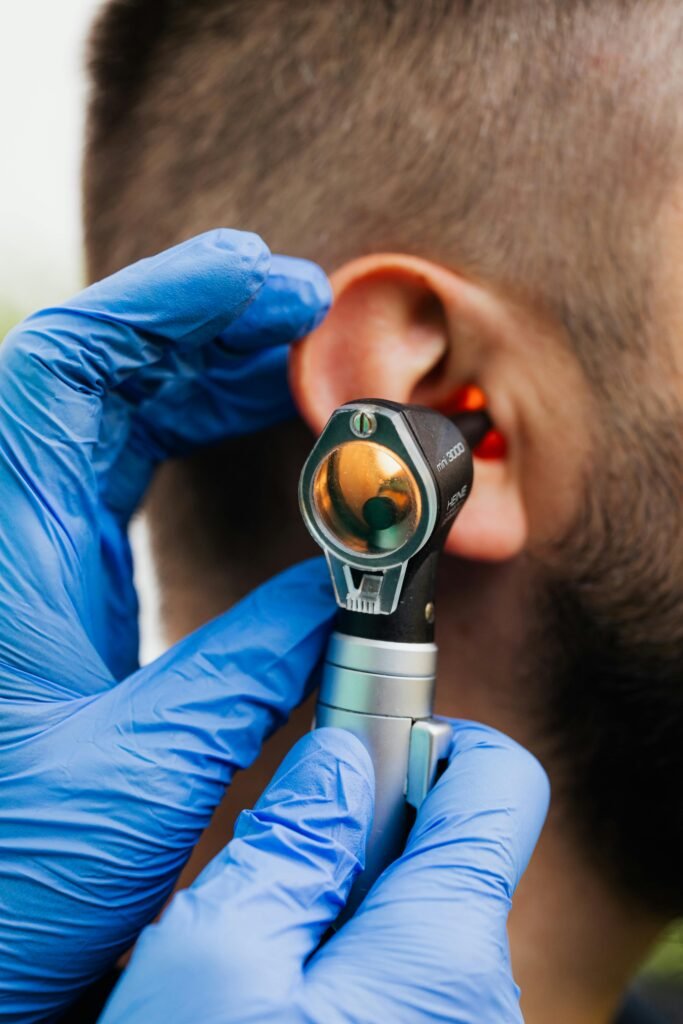 Close-up of a doctor using an otoscope to examine a patient's ear.